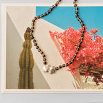 brown beaded necklace with silver shell pendant