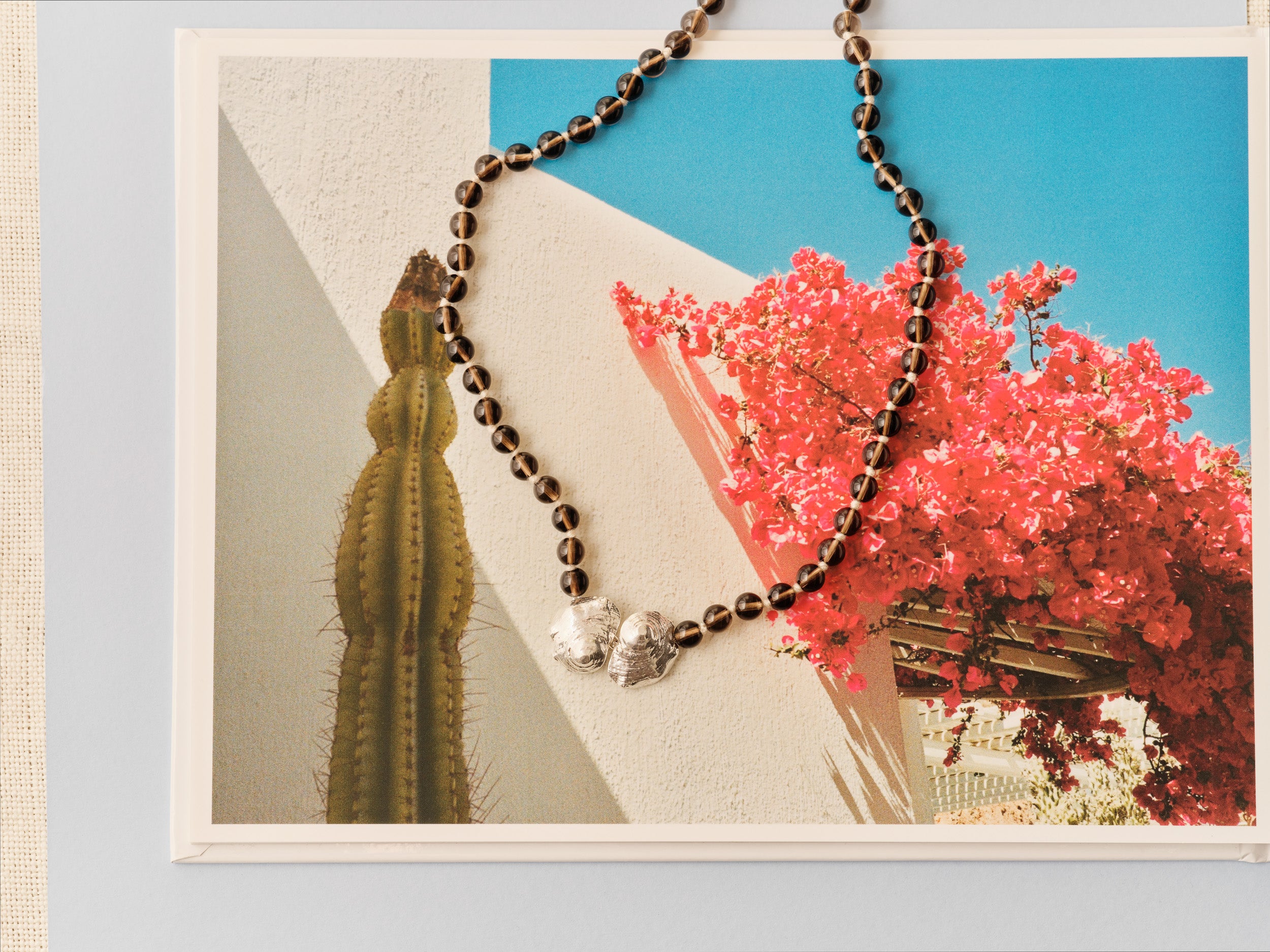 brown beaded necklace with silver shell pendant